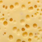 O texto da Bloomberg relata que a Great Lakes Cheese Co. está gastando mais de US$ 700 milhões em uma fábrica em Nova York para dobrar a produção de leite da empresa. queijo