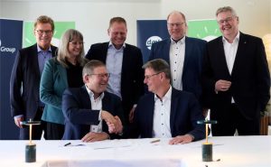 Leite europeu. Jan Toft Nørgaard, presidente da Arla Foods, aperta a mão de Heinz Korte, presidente do DMK Group, ao lado dos principais acionistas de ambas as cooperativas (Arla Foods/Arla Foods).