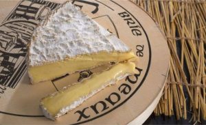 Vídeos, ferramentas antigas e uma pá de brie: assim a Maison du Brie de Meaux mostra o processo do queijo, do leite ao amadurecimento.